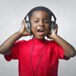 young black boy w headphones singing cropped shutterstock_1803887911